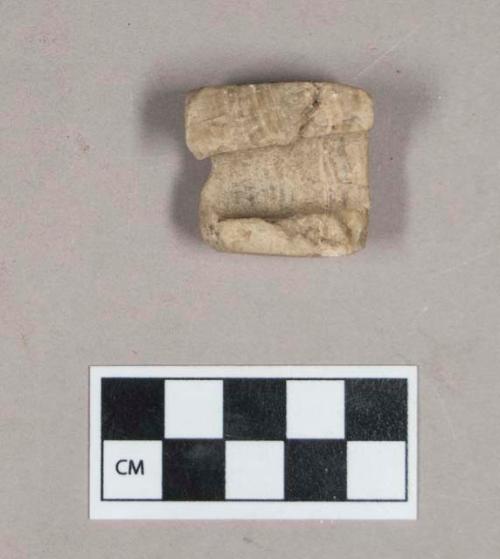 Ground stone, perforated stone fragment, square corners, possible pipe bowl fragment