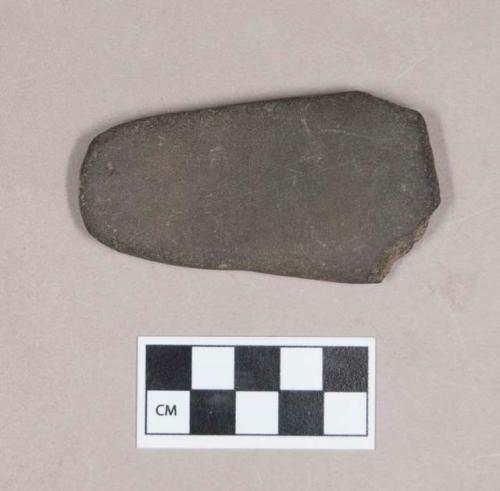 Ground stone, worked flat stone, chipped at one edge, possible adze preform