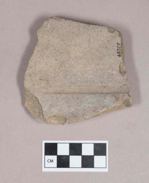 Ground stone, flat stone fragment, one side smoothed with one groove, possible abrading stone