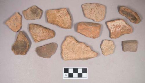 Earthenware vessel rim, body, and foot ring base sherds. Most with red painted exterior and interior. Some with white painted exterior and interior. One piece of a reddish chert flaking debitage and one unaltered stone (possibly limestone).