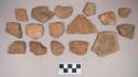 Earthenware vessel rim, body, and foot ring base sherds. Most with red painted interior and exterior. Some with white painted exterior and red painted interior. Nine rocks, mostly limestone, including two rounded pebbles and also one piece of chert.