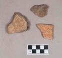 Earthenware vessel body sherds with red painted interior and exterior. Some charring.