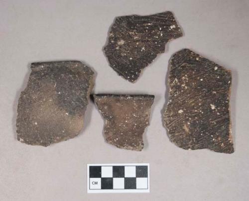 Ceramic, earthenware body and rim sherds, body sherds cord-impressed, one rim sherd fiber-impressed, one rim sherd with incised rim and undecorated body, shell-tempered