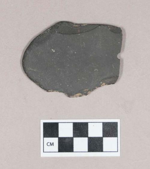 Ground stone, worked stone fragment, flat, one end rounded, one perforation, fragmented at perforation, possible gorget fragment