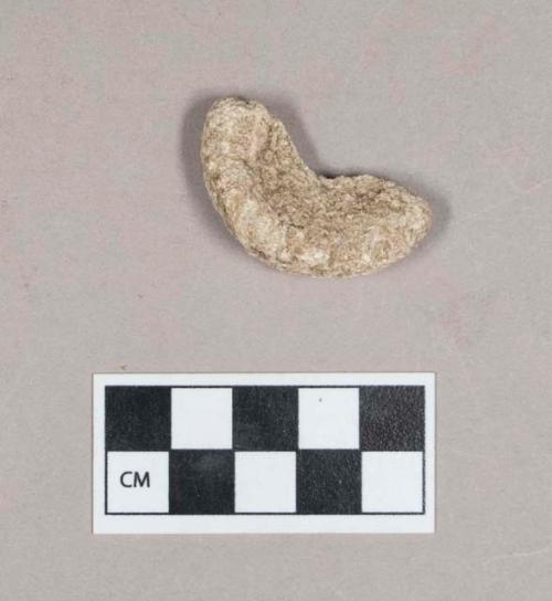 Ground stone, discoidal stone fragment, concave on both sides, likely perforated in center