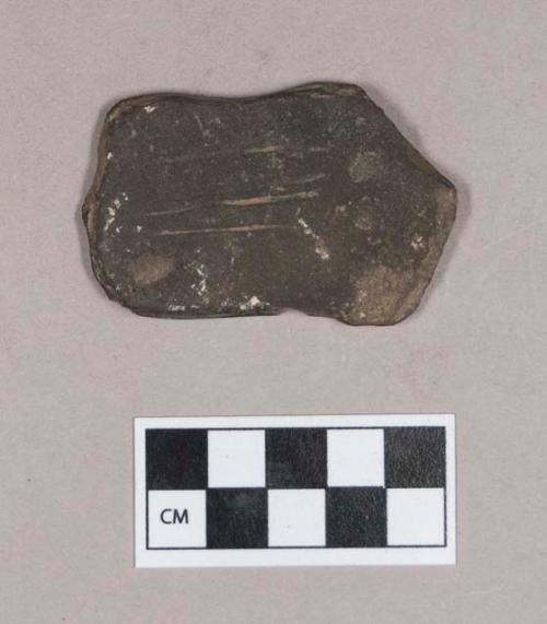 Ground stone, pecked and ground stone object, flat, incised grooves on one side