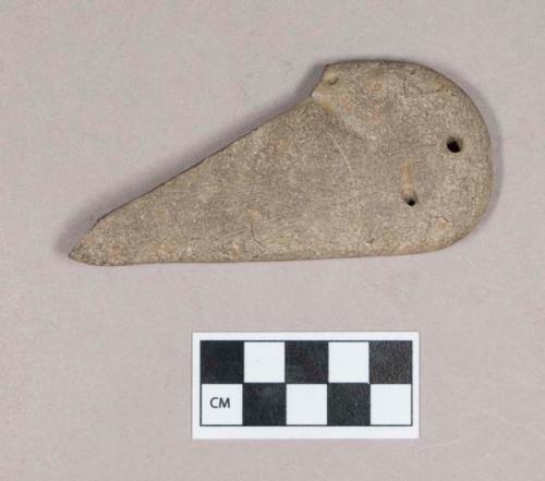 Ground stone, worked stone fragment, flat, one end rounded, two possibly natural perforations, incised on one side