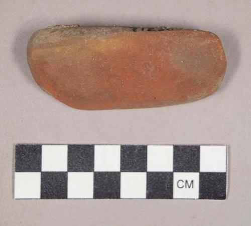 Ground stone, modified lithic, covered in red ochre