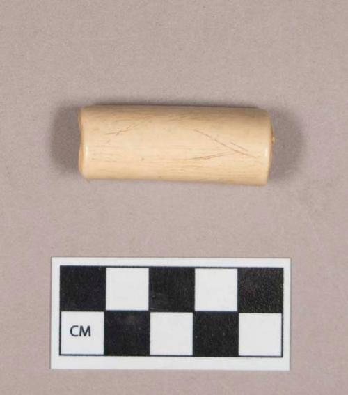 Cut and worked animal bone tube, polished, possibly incised