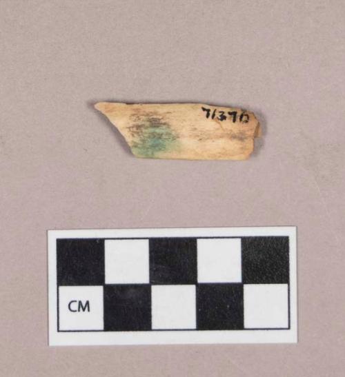 Worked animal bone fragment, stained with copper