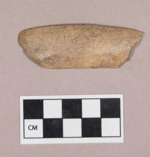 Worked antler fragment, one side smoothed, one side possibly incised, one end sharpened