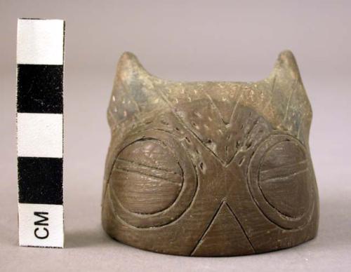 Pottery lid in shape of human face with incised decoration