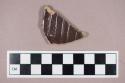 Ceramic, earthenware, stoneware body sherd with salt-glazed exterior and brown interior slip, possible ink master fragment