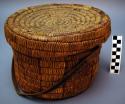 Medium size utility basket with lid. Coiled around flat wood strips.