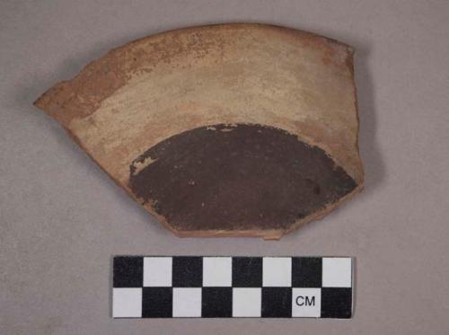 Rim sherd of small plate - black decoration on face, narrow black band on back