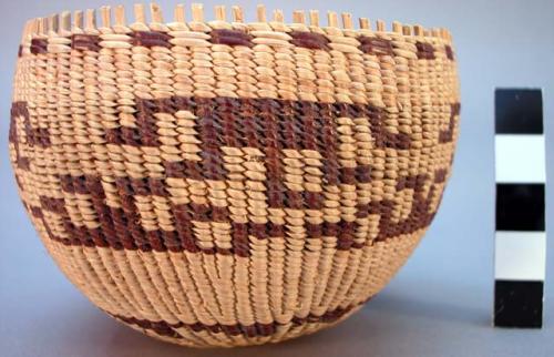 Small circular twined basket with light tan and brown geometric design bands