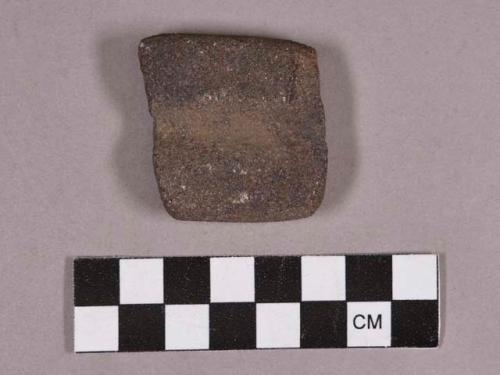 Ground stone, abrading stone fragment, grooved both sides