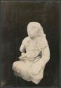 Carved stone seated human figure