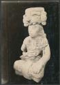 Carved stone seated human figure with headdress