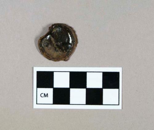 Ferrous metal, bottle cap fragment with synthetic lining