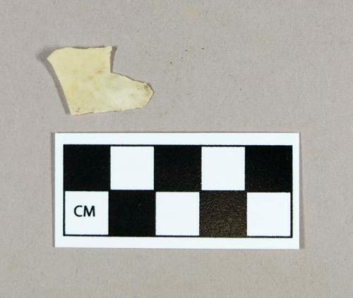 Synthetic, yellowish white plastic fragment