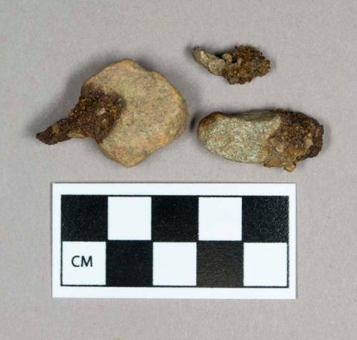 Stone, pebbles with attached corroded metal