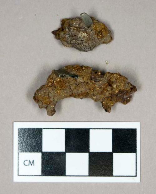 Metal, heavily corroded iron fragments with small aqua flat glass fragments attached