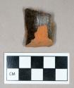 Ceramic, redware with dark brown glaze on interior and exterior, could be either a rim or handle sherd