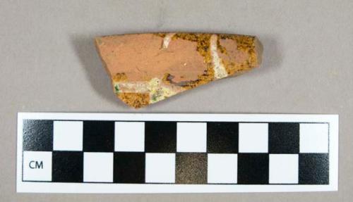 Ceramic, clear glazed redware rim sherd with yellow slip and green decoration