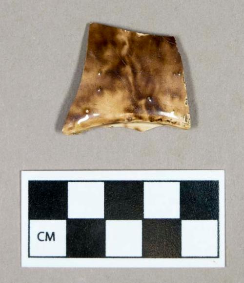 Ceramic, creamware base sherd, brown clouded/variegated decoration on exterior