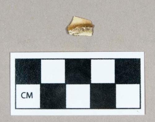 Ceramic, creamware base sherd with brown spalling