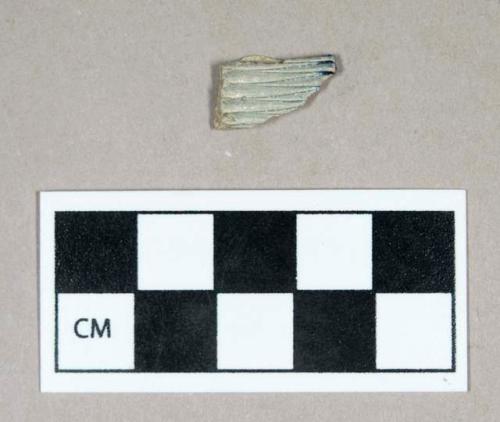 Ceramic, buff-bodied stoneware body sherd with zig-zagged incisions and faint blue spalling