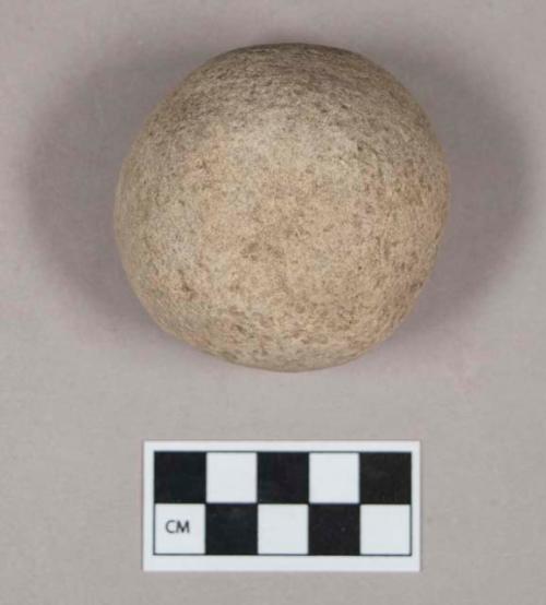 Ground stone, pecked and ground hemispherical stone object, pitted on flat side