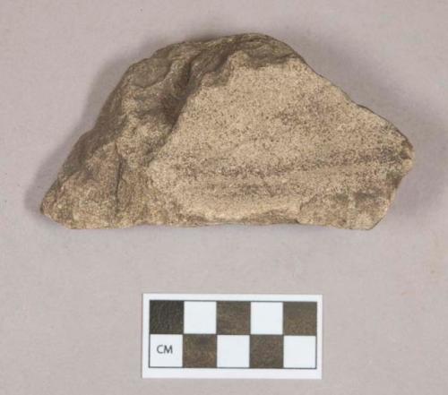 Ground stone, abrading stone fragment, grooved on one side