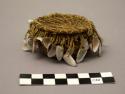 Small covered pine needle basket with small clam shells dangling; lined