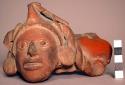 Pottery head from vessel - part of vessel attached