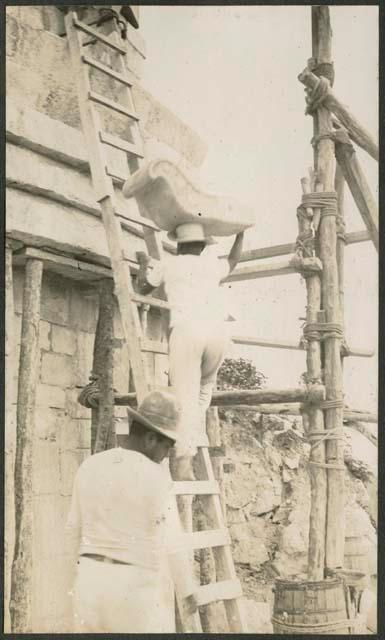 Caracol, worker carrying stone nose up ladder for restoration of mask panel