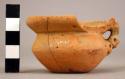 Broken unpainted small vessel with 1 handle & punctated figure