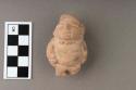 Archaic pottery figurine- legless man with pack on back