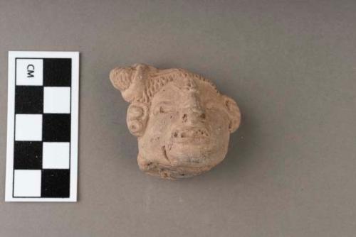 Moulded pottery figurine - small head with grotesque cap