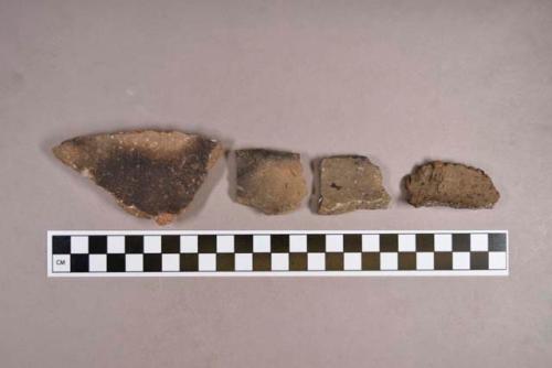 Ceramic, earthenware rim and body sherds, shell-tempered, cord impressed, incised, and undecorated, one ochre-stained