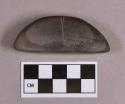 Ground stone, semi-lunar shaped object, incised in middle