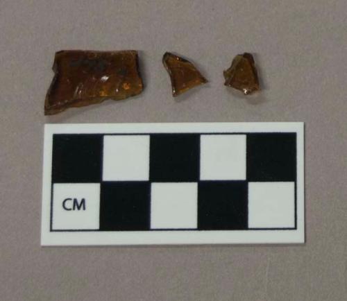 Glass, curved amber bottle body fragments