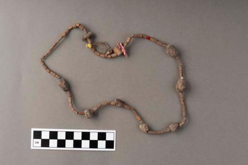 Necklace of plant material, pink plastic piece and yellow bead