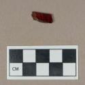 Synthetic, red plastic fragment