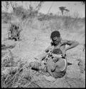 Woman of Band 11 putting an ostrich eggshell headband on her child