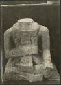Carved stone human figure without head