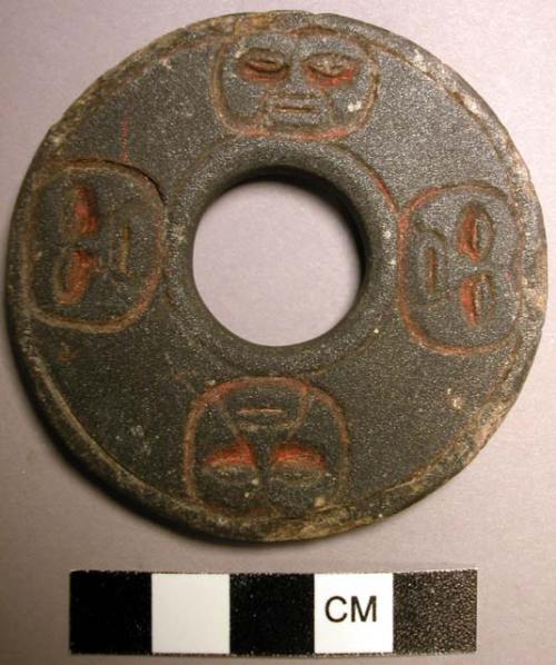 Stone ring with faces and red pigment on it