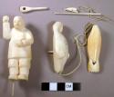 Ivory man on whalebone platform with 6 ivory implements and 2 ivory seals.