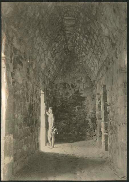 Monjas, boy in doorway of interior chamber